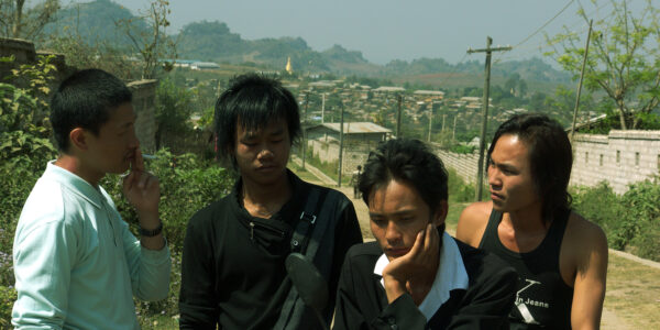 A group of four young men standing outdoors