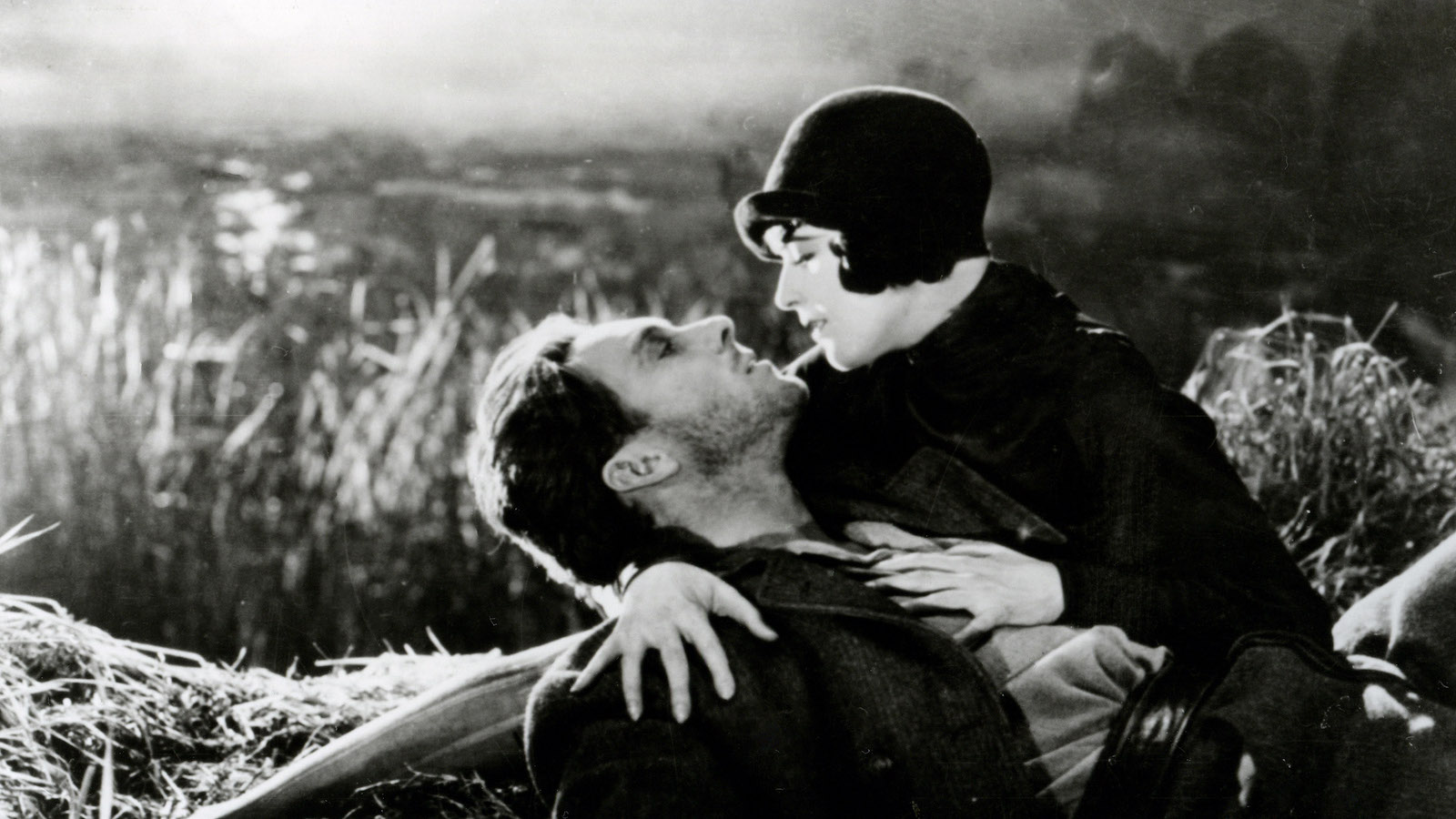 A woman embracing a man in front of a river