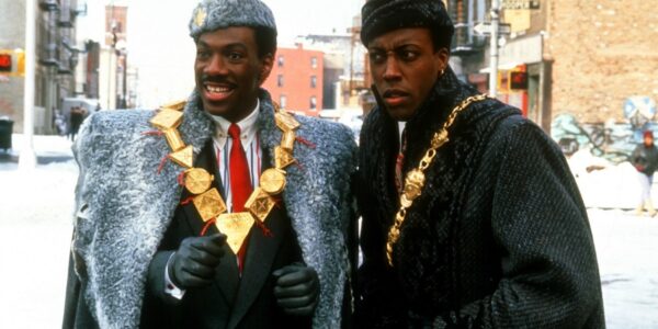 Two men wearing fur coats and medallions on a NYC street