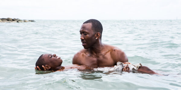 A man holding a child floating on his back in the ocean