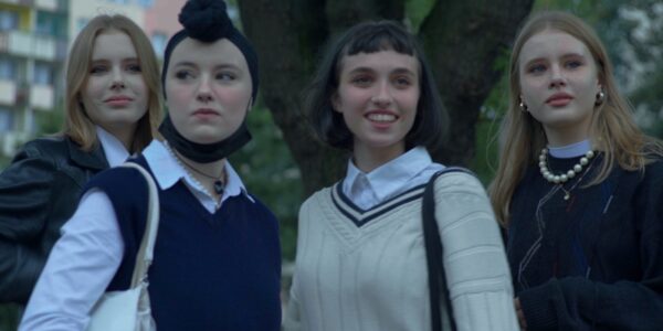 Four teenage girls look towards camera