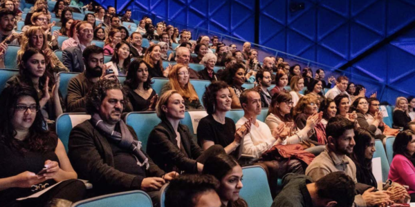 A filled Redstone movie theater with audiences looking towards the screen