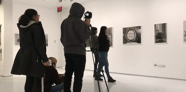 Silhouettes of teens filming visitors walking through the Museum