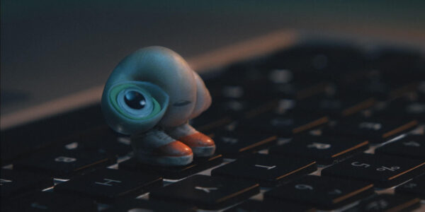 A tiny shell with shoes perches on a keyboard