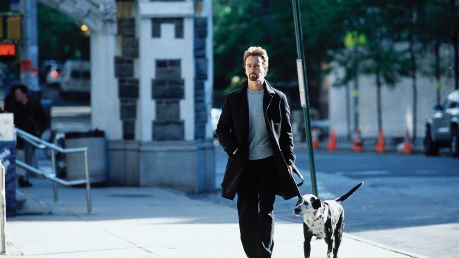 A man walks a dog on a New York street