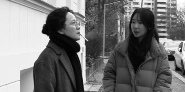 Two women in coats stand outside