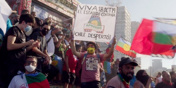Protestors in the street holding signs in South America