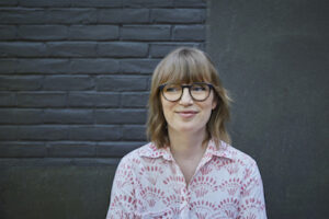 Sarah Polley, a woman in glasses, smiles at camera