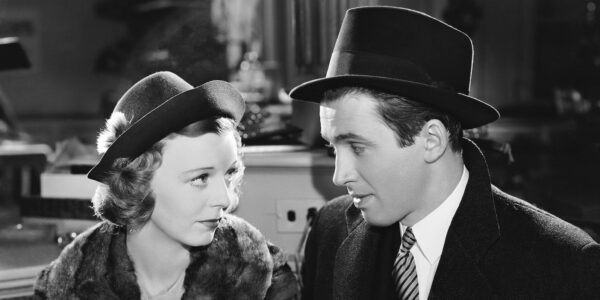 A man and a woman in hats sitting in restaurant looking at each other