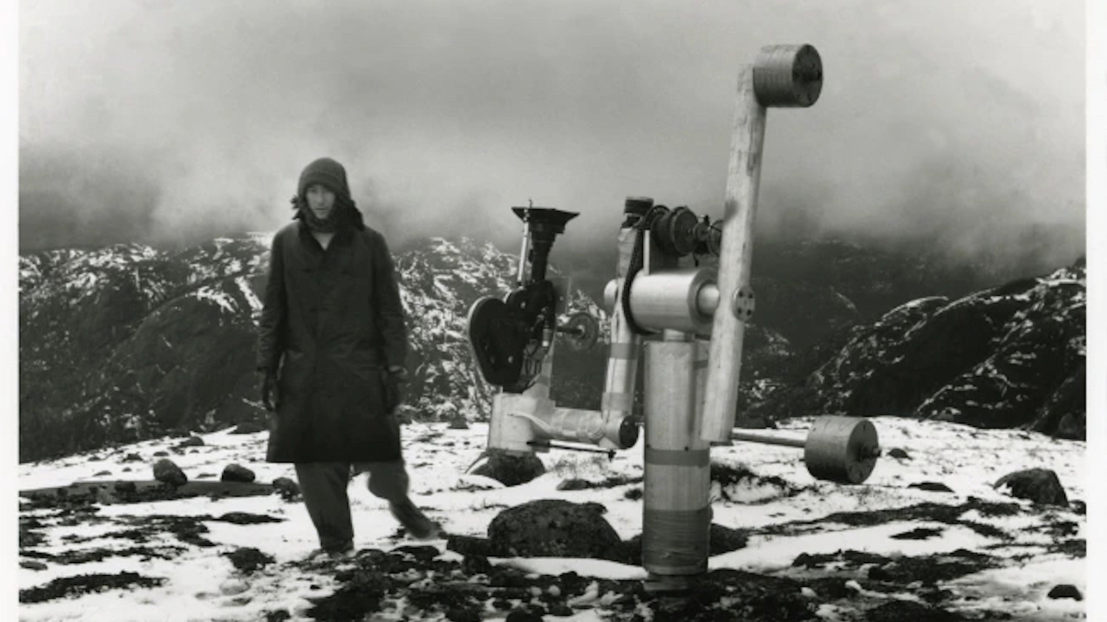 La Region Centrale A man stands on a mountaintop next to an apparatus with a telescope