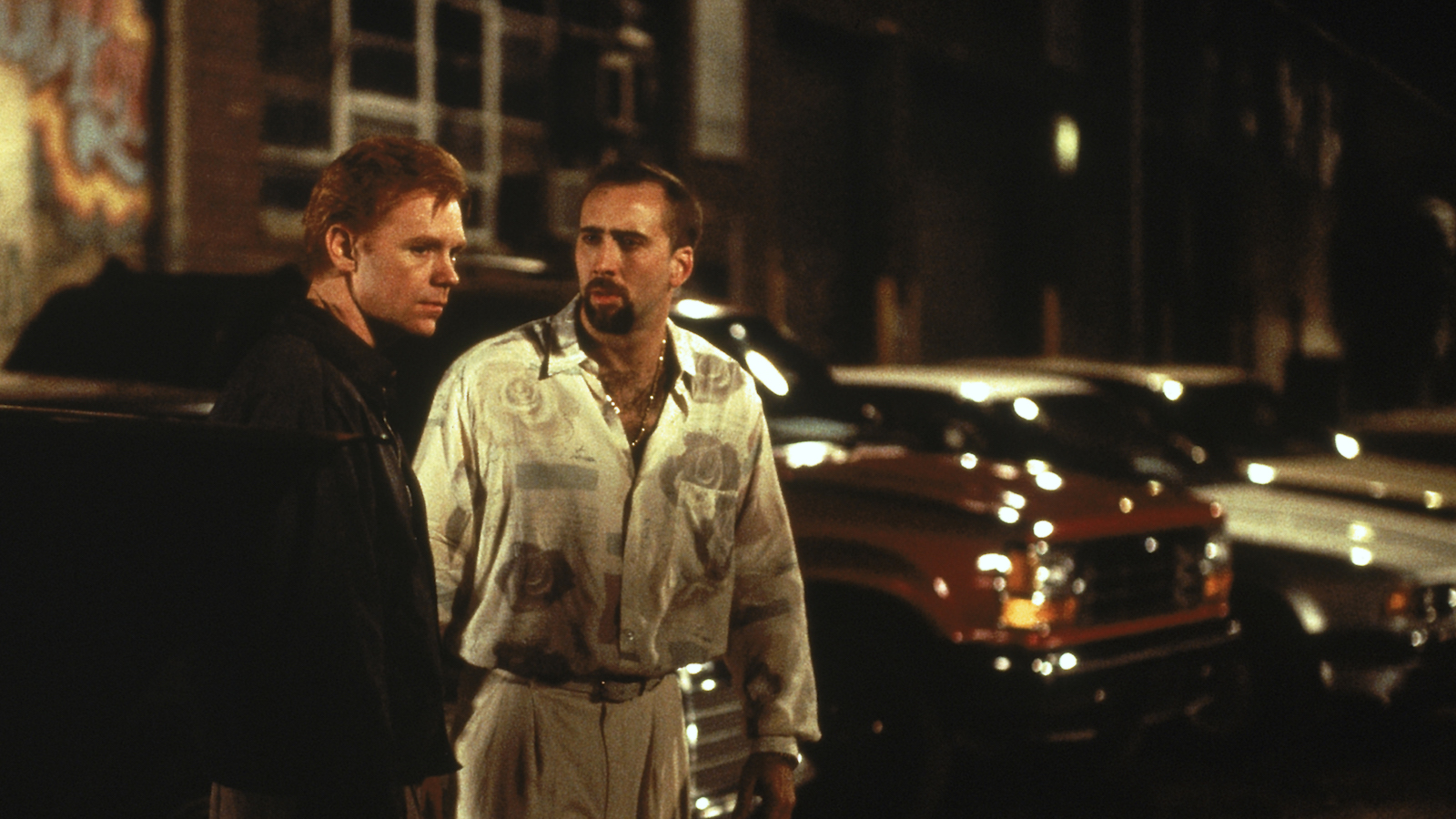 kiss of death 1995 Two men with intense expressions stand in a parking lot; the man with a goatee looks intently at the red-headed man, looking away.