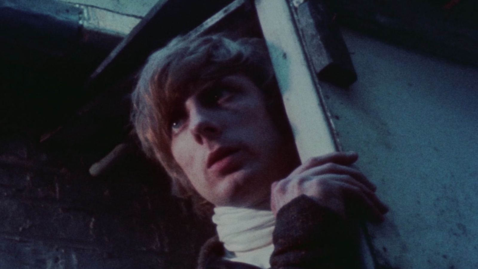 A man intensely looks out a window