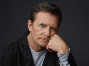 A man looks at camera with his head resting on his fist