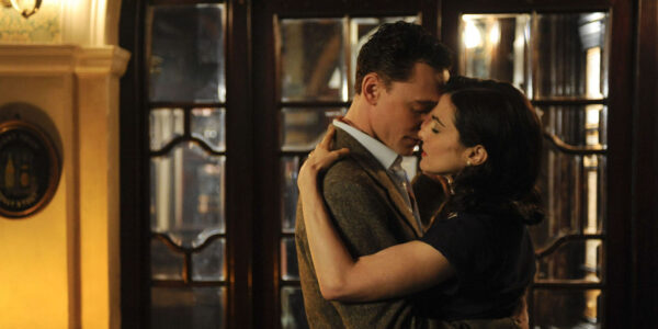A man and woman dance, holding each other passionately with eyes closed