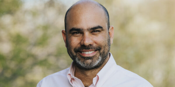 Headshot photo of a smiling man in collared shirt