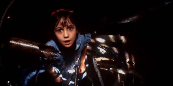 A little girl looks up with astonishment from a dark tunnel