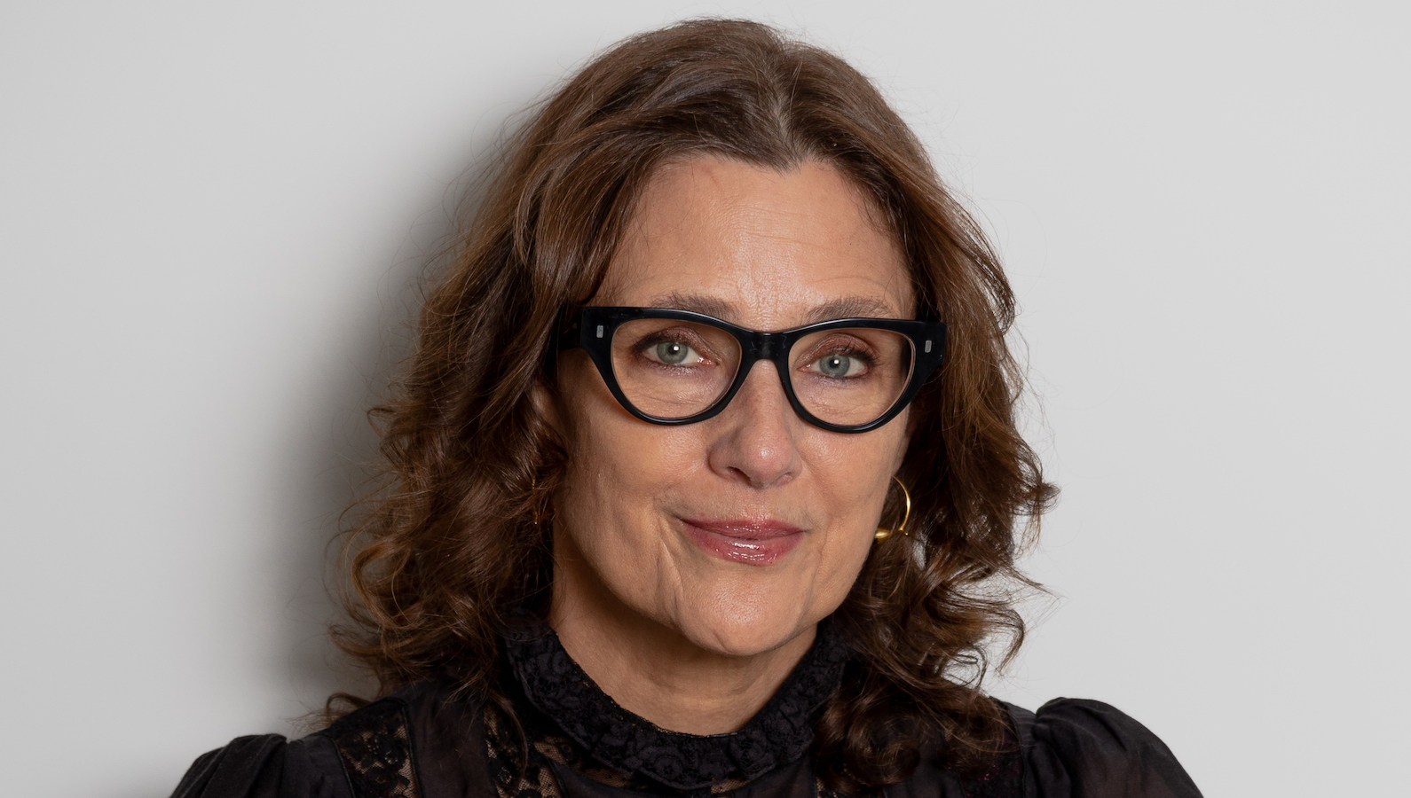 A woman with glasses looks at camera
