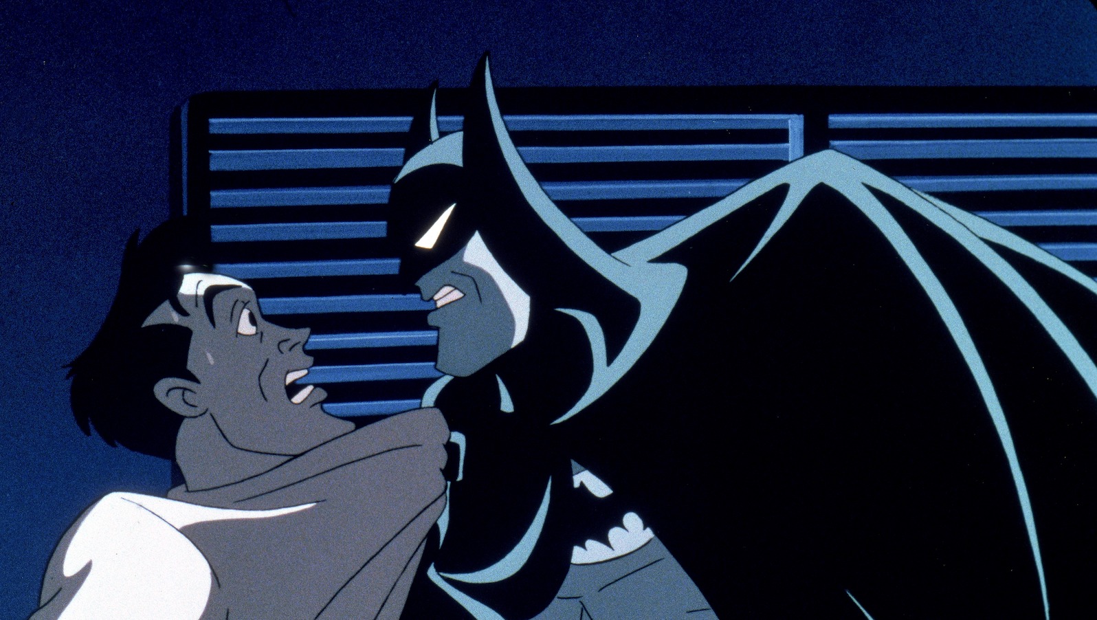 Batman grabs a frightened man by the shirt and scowls at him
