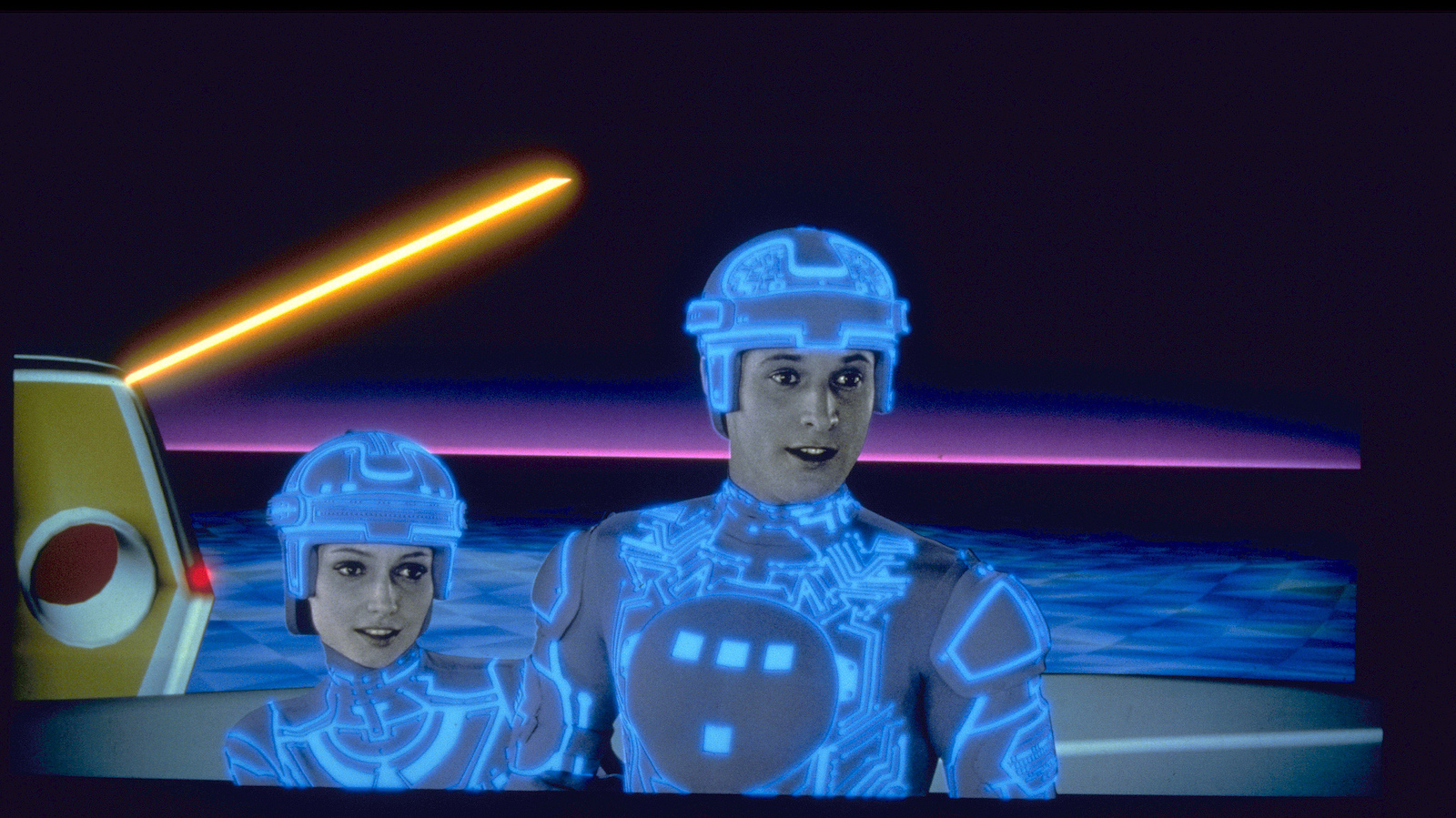 two people with glowing body suits and helmets stand in a sparse virtual world