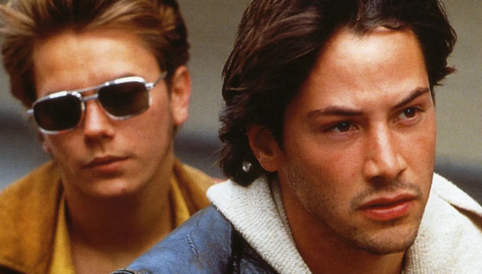 My Own Private Idaho A blond man in sunglasses and yellow jacket sits behind a dark-haired man in a jean jacket and white collar, both looking forward as though on a motorcycle