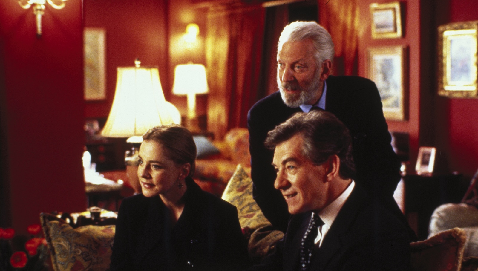 Six Degrees 1 Three people, two men and a woman, lean forward expectantly, on a couch as they look at someone off screen.