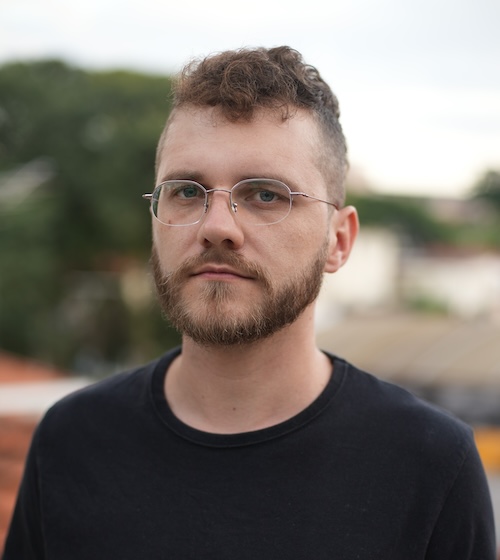 A bespectacled person poses for the camera