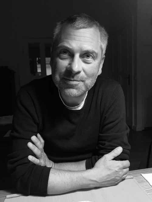 black and white photo of a man smiling towards camera, posing for photo