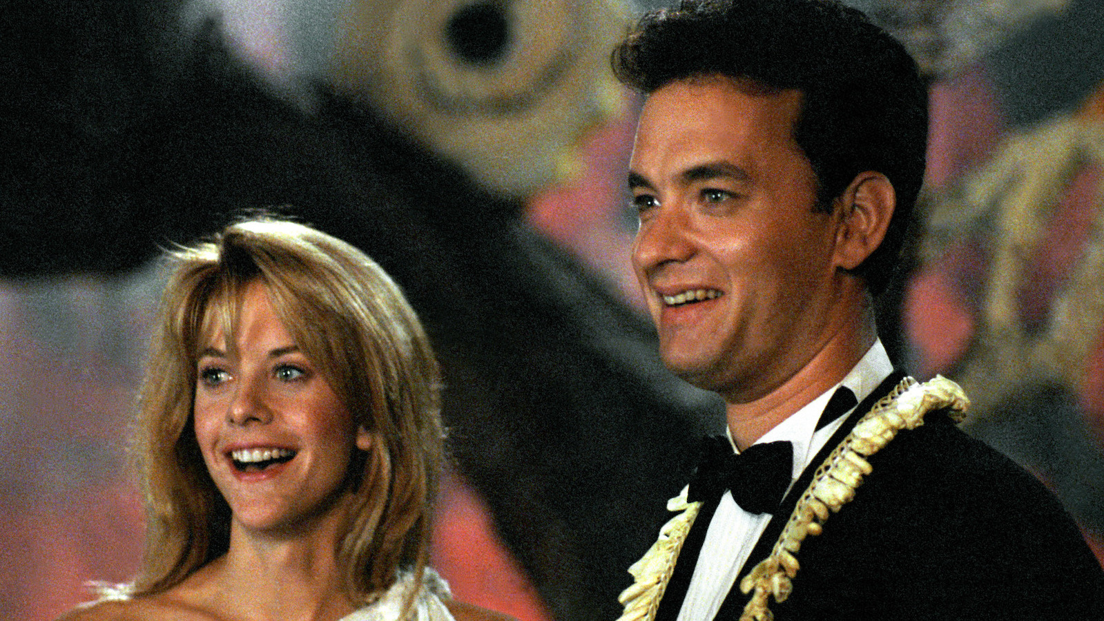 A dark haired man and blonde woman smiling happily