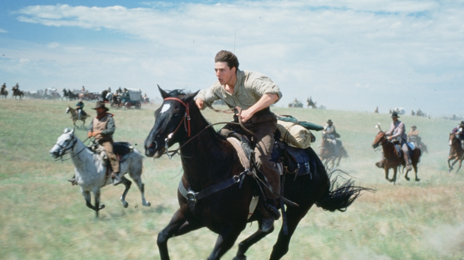 Far and Away A man furiously rides a horse across a prairie, surrounded by other men on horses.