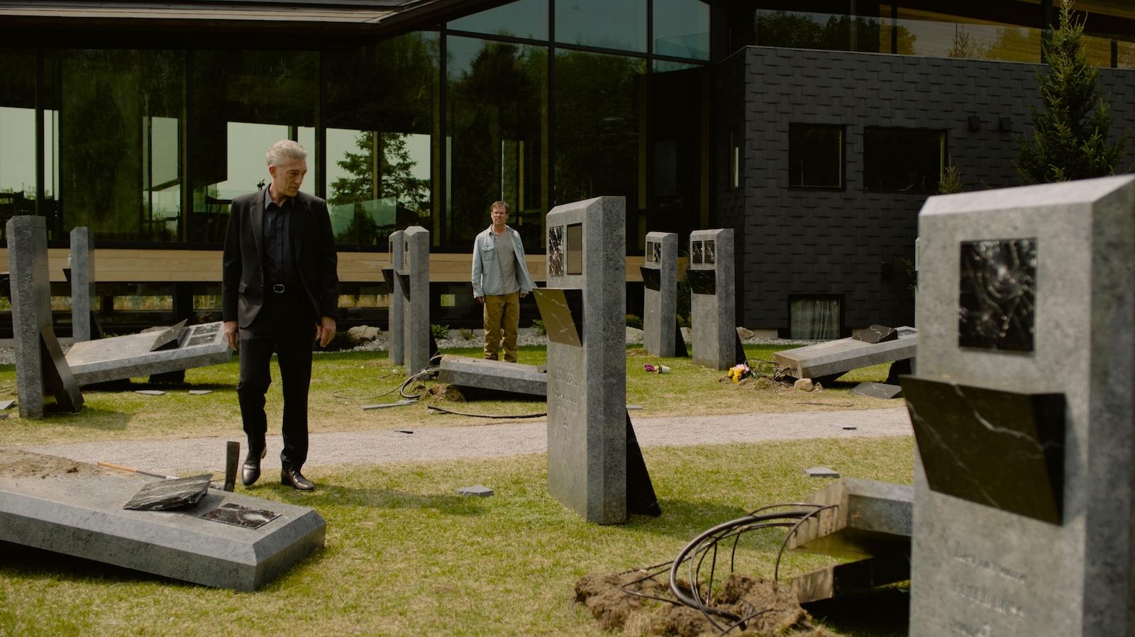 A desecrated graveyard with tombs toppled over and wires coming out of them