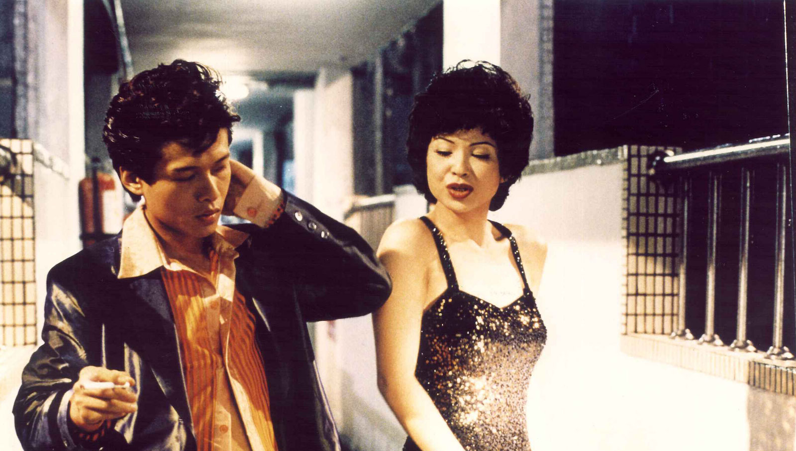Two Taiwanese performers dressed up in retros 50s American clothes dance near each other in an apartment hallway