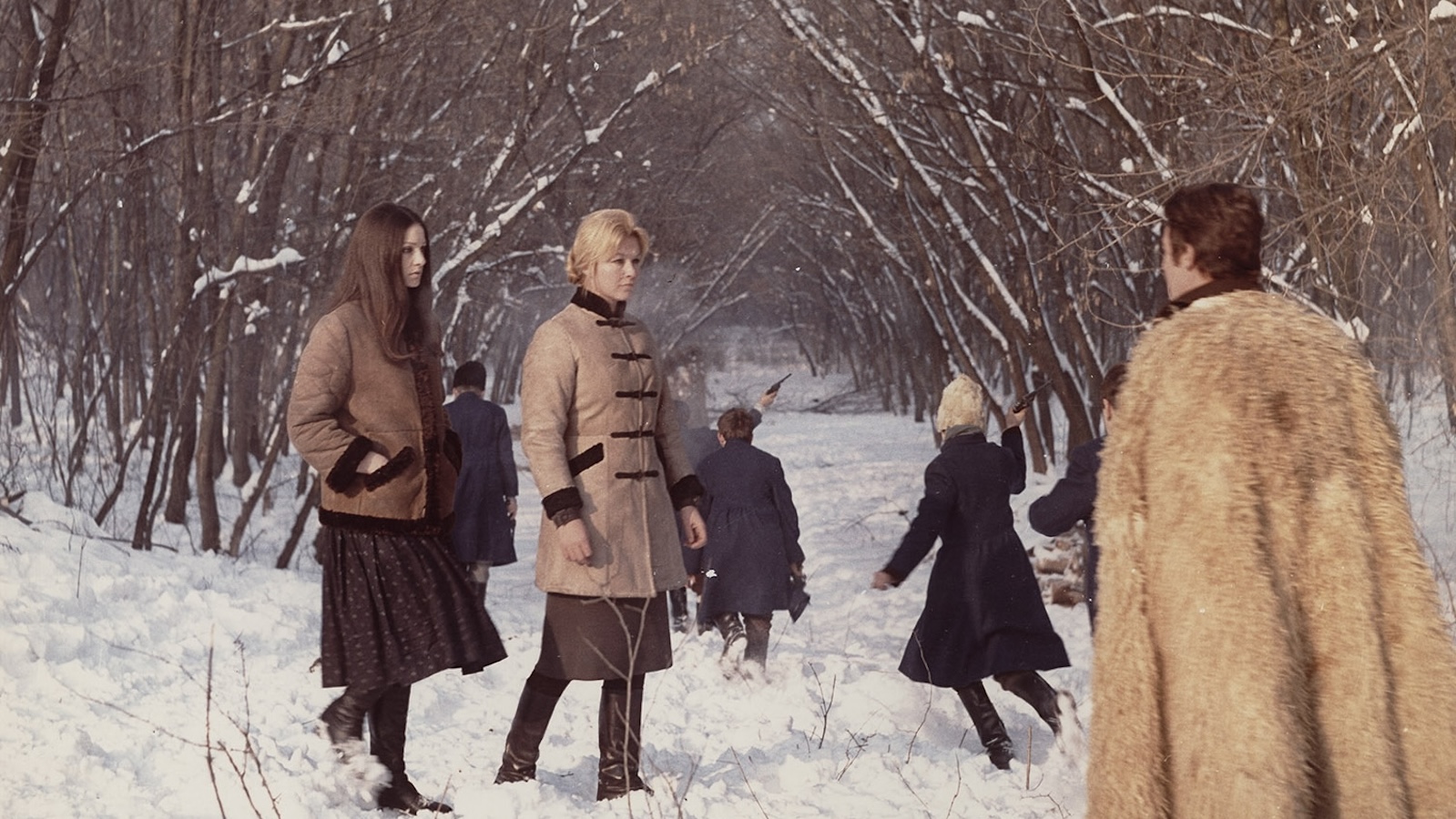People stand in a snowy wooded landscape