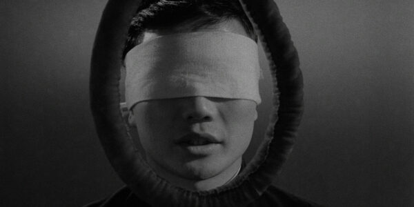 A blindfolded man's head is framed by a noose.