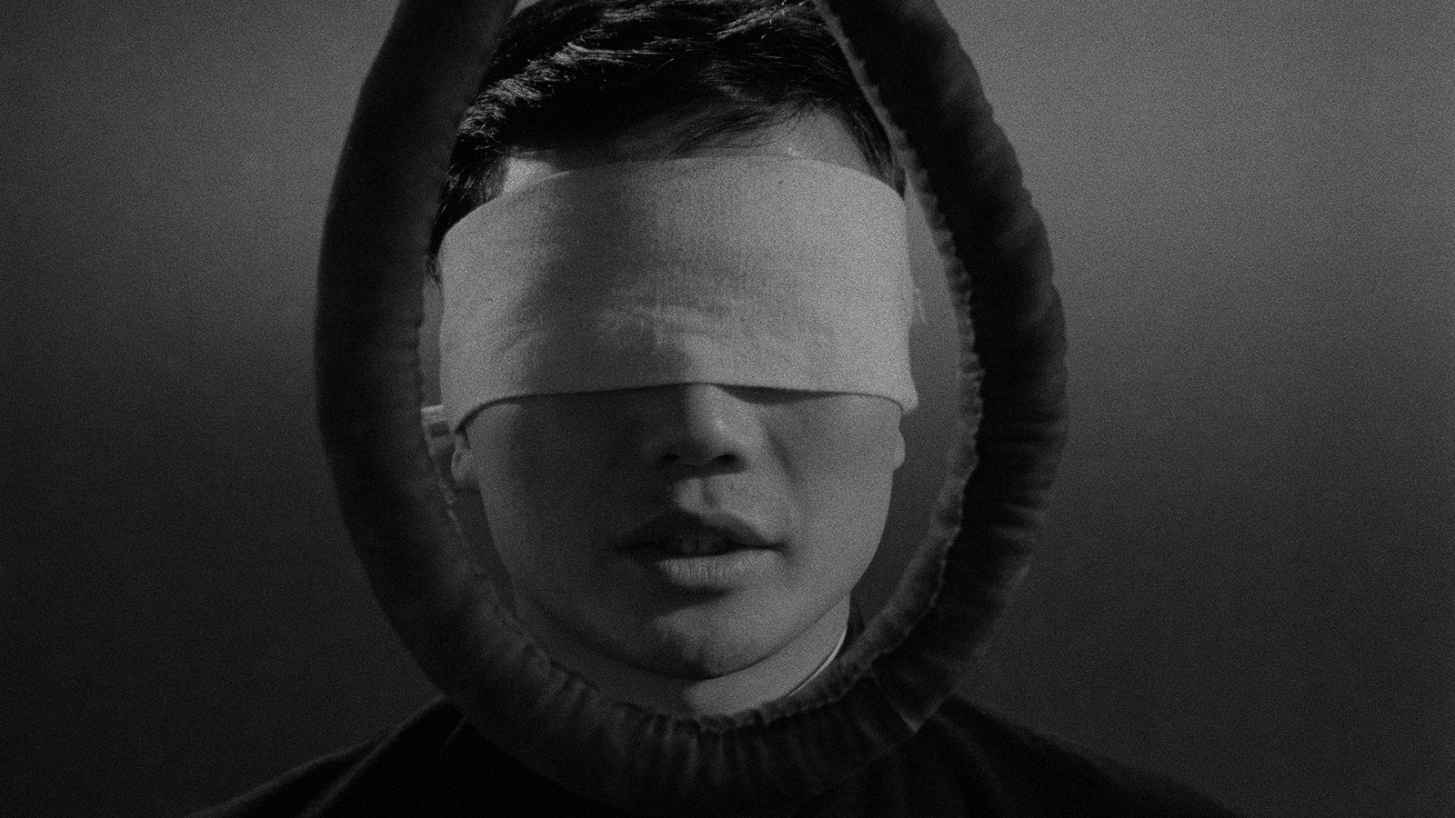 A blindfolded man's head is framed by a noose.