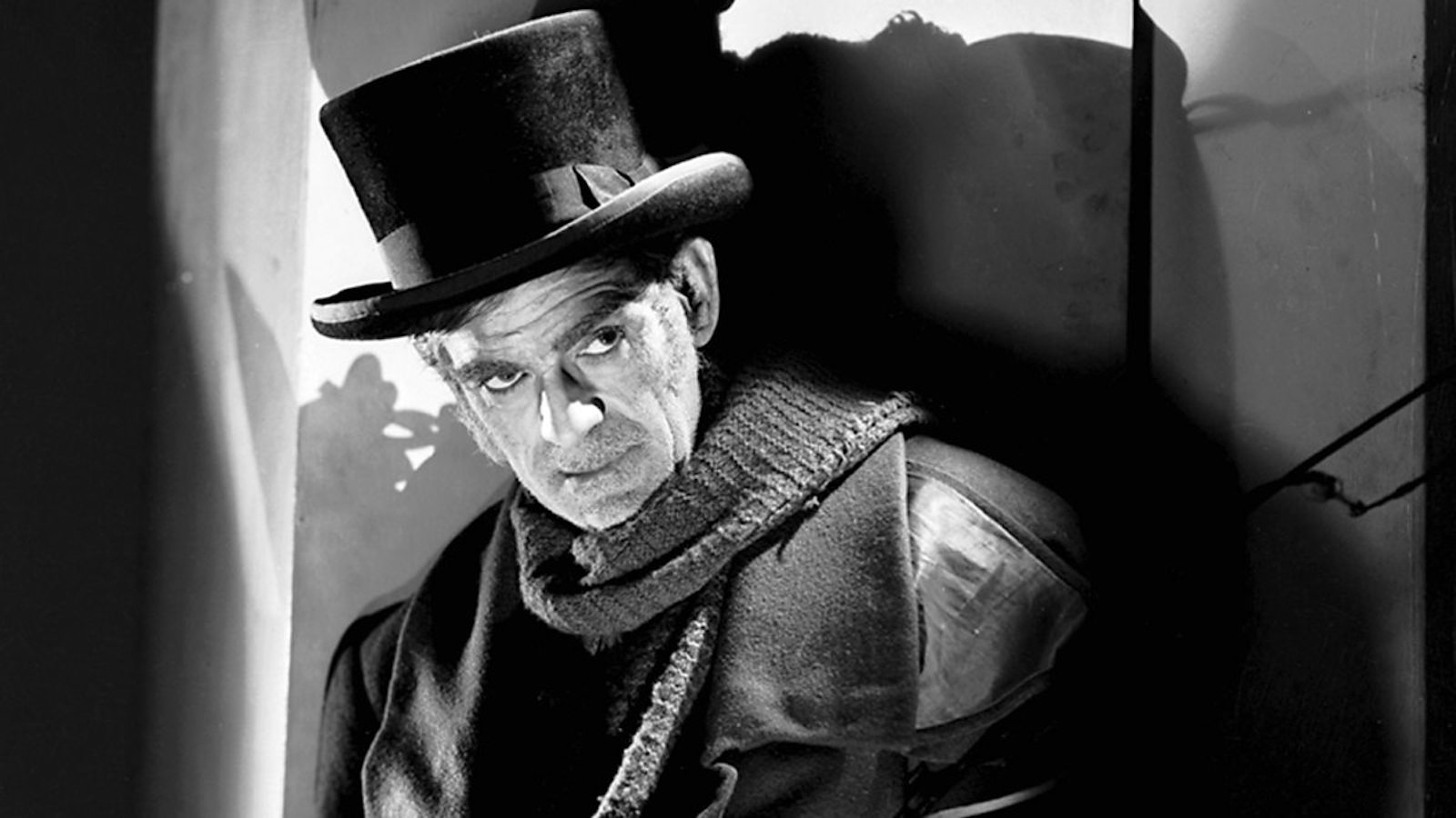 A sinister man in a top hat and scarf.