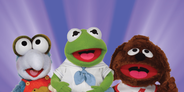 Three puppets in a row, one a Gonzo, one a frog, and one a dog. They are Muppet Babies against a background of radiating bluish purple rays.
