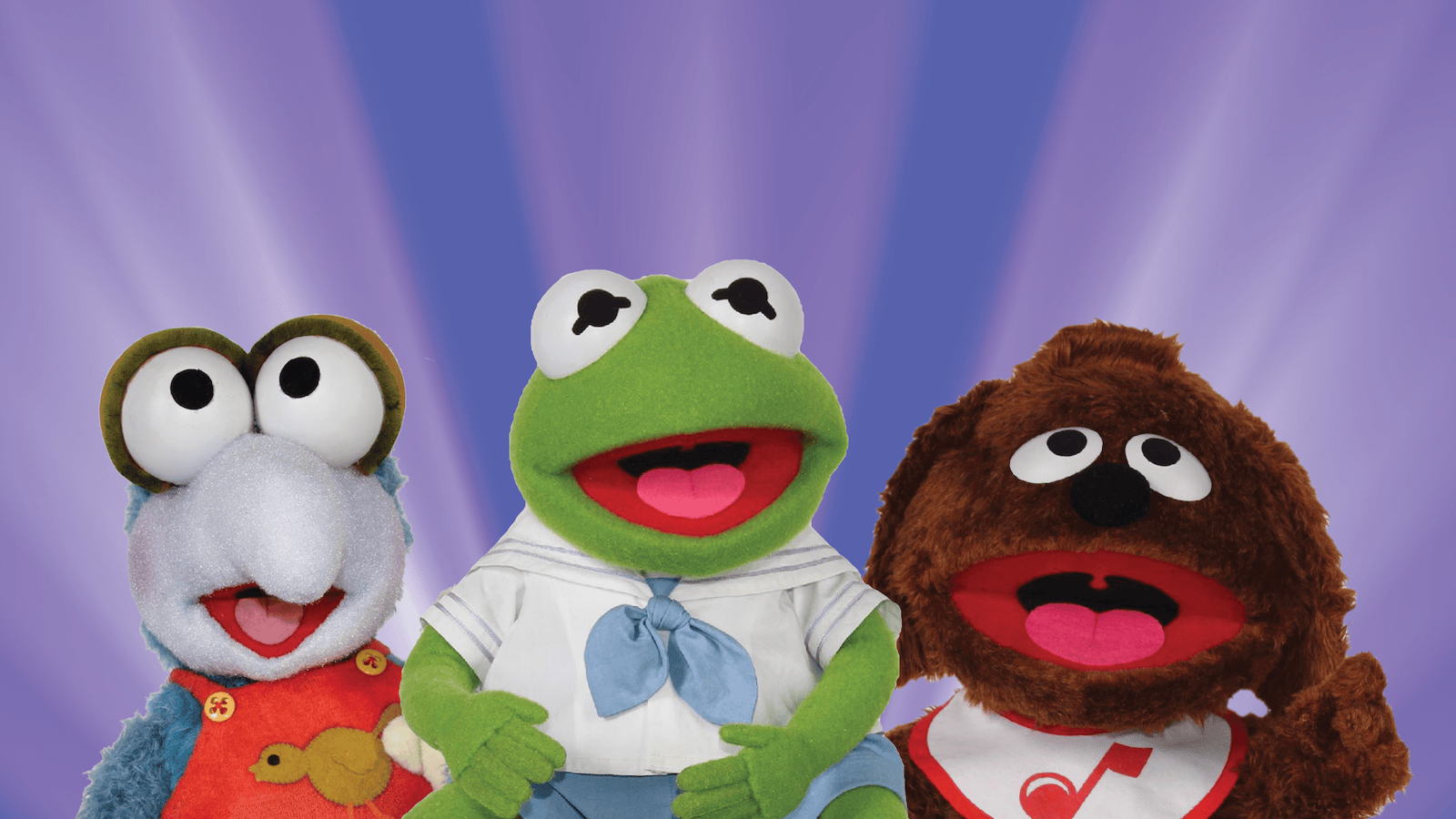 Three puppets in a row, one a Gonzo, one a frog, and one a dog. They are Muppet Babies against a background of radiating bluish purple rays.